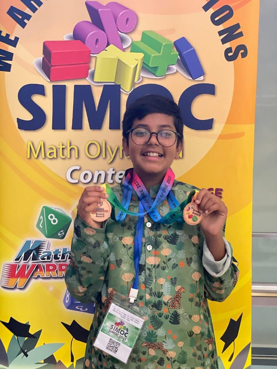 Tanish Jain holding contest medals